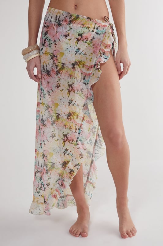 Flowing woven cotton beach skirt with eye-catching tie-dye pattern
        Feminine ruffle detailing along the edges for added movement
        High-slit design offering adjustable coverage and effortless movement
        Lightweight fabric perfect for warm-weather destinations
        Versatile wrap style that can be tied at desired height
    
    This breezy Nasty Gal beach skirt combines carefree style with practical beachwear functionality. The lightweight cotton construction ensures comfort during hot days by the shore, while the distinctive tie-dye pattern captures the essence of summer escapism. Wrap it around your waist as a chic cover-up when heading from the beach to a seaside caf, or style it with a matching triangle bikini top as shown for a coordinated look. The ruffle detailing adds a playful, feminine touch that catches the gentle sea breeze beautifully. Perfect for your holiday wardrobe, this versatile piece transitions effortlessly from poolside lounging to casual sunset strolls along the promenade. Pair with simple sandals and statement jewellery for an impromptu beach party, or throw on over your favourite swimwear for instant style when the ice cream van arrives.