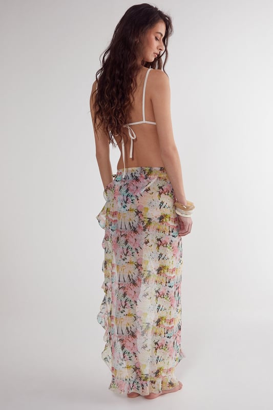 Flowing woven cotton beach skirt with eye-catching tie-dye pattern
        Feminine ruffle detailing along the edges for added movement
        High-slit design offering adjustable coverage and effortless movement
        Lightweight fabric perfect for warm-weather destinations
        Versatile wrap style that can be tied at desired height
    
    This breezy Nasty Gal beach skirt combines carefree style with practical beachwear functionality. The lightweight cotton construction ensures comfort during hot days by the shore, while the distinctive tie-dye pattern captures the essence of summer escapism. Wrap it around your waist as a chic cover-up when heading from the beach to a seaside caf, or style it with a matching triangle bikini top as shown for a coordinated look. The ruffle detailing adds a playful, feminine touch that catches the gentle sea breeze beautifully. Perfect for your holiday wardrobe, this versatile piece transitions effortlessly from poolside lounging to casual sunset strolls along the promenade. Pair with simple sandals and statement jewellery for an impromptu beach party, or throw on over your favourite swimwear for instant style when the ice cream van arrives.