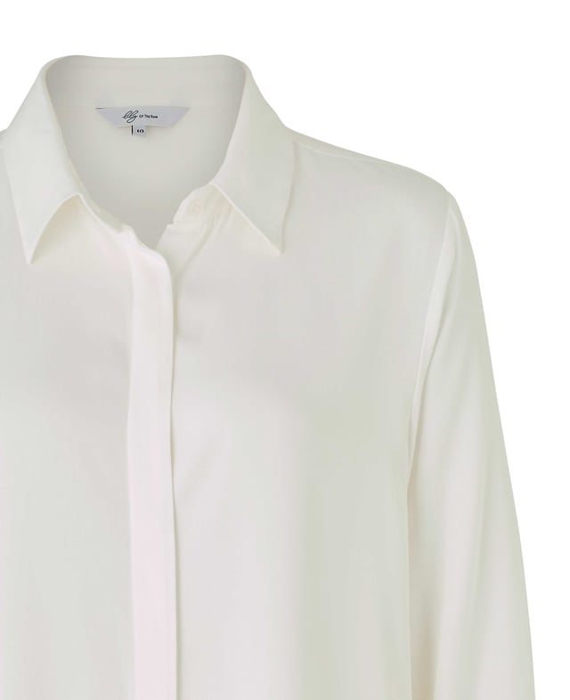 Elevate your everyday wardrobe with this off-white viscose twill boyfriend-fit shirt that exudes understated luxury. Its silky-soft fabric is light yet durable, flowing effortlessly as you move. The clean lines of the small collar and fly-front give it a minimalist chic vibe, while the scooped hem lends a casual, relaxed finish. Perfectly versatile, it can be tucked into tailored trousers for a polished look or left loose over your favorite jeans for a laid-back, elegant feel. Its neutral tone makes it the perfect layering piece. 100% viscose twill, soft and drapey. Small neat collar. Fly front concealed buttons. Scooped hem. Boyfriend fit. Long sleeves with single buttoned cuff. Wash at 30°C on a gentle cycle.