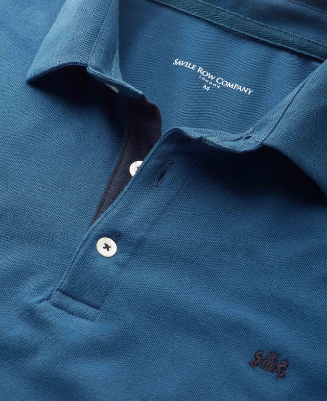 Our long-sleeved polos are a versatile addition to your smart-casual collection-proving a popular choice for weekends, working from home and dress-down Fridays. This version in denim blue has been made from a soft cotton-pique fabric in a classic fit for optimum comfort. There's contrast detailing on the inside neck placket, while our trademark crest embroidery and herringbone side slits finish things off. 180gram pique 100% cotton. Classic fit with long sleeve. Self fabric two piece collar. Contrast inside neck placket, cross stitching on button placket, crest embroidery and herringbone in side slit. 2 button placket. Contrast embroidered crest on chest. Machine wash at 30°C.