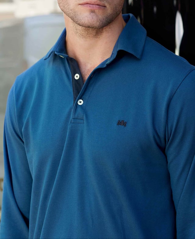 Our long-sleeved polos are a versatile addition to your smart-casual collection-proving a popular choice for weekends, working from home and dress-down Fridays. This version in denim blue has been made from a soft cotton-pique fabric in a classic fit for optimum comfort. There's contrast detailing on the inside neck placket, while our trademark crest embroidery and herringbone side slits finish things off. 180gram pique 100% cotton. Classic fit with long sleeve. Self fabric two piece collar. Contrast inside neck placket, cross stitching on button placket, crest embroidery and herringbone in side slit. 2 button placket. Contrast embroidered crest on chest. Machine wash at 30°C.