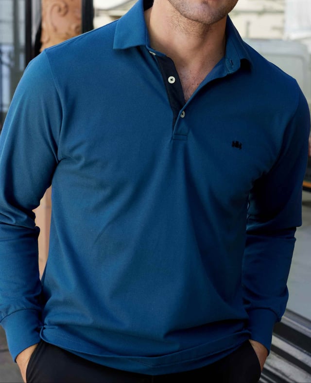 Our long-sleeved polos are a versatile addition to your smart-casual collection-proving a popular choice for weekends, working from home and dress-down Fridays. This version in denim blue has been made from a soft cotton-pique fabric in a classic fit for optimum comfort. There's contrast detailing on the inside neck placket, while our trademark crest embroidery and herringbone side slits finish things off. 180gram pique 100% cotton. Classic fit with long sleeve. Self fabric two piece collar. Contrast inside neck placket, cross stitching on button placket, crest embroidery and herringbone in side slit. 2 button placket. Contrast embroidered crest on chest. Machine wash at 30°C.