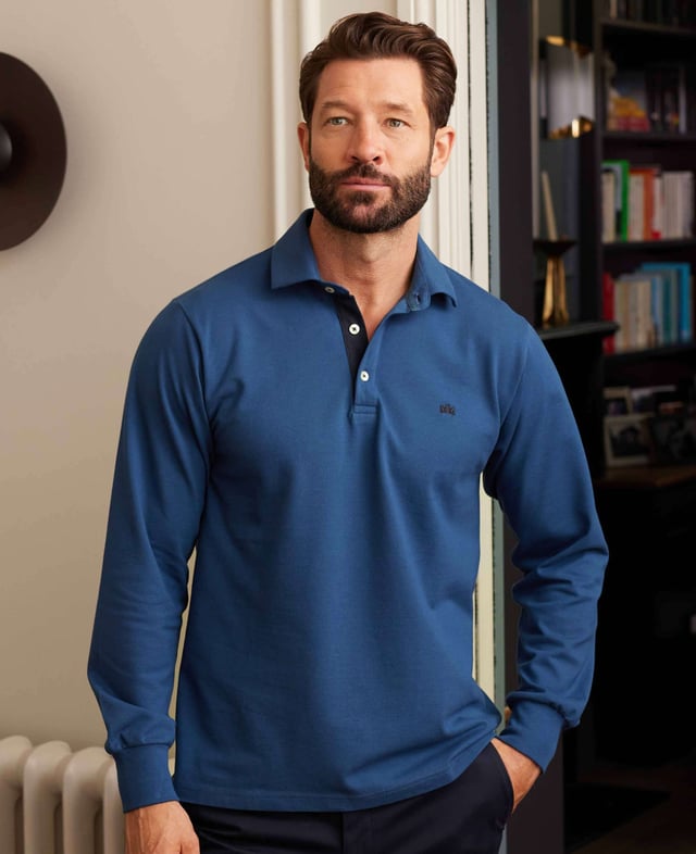 Our long-sleeved polos are a versatile addition to your smart-casual collection-proving a popular choice for weekends, working from home and dress-down Fridays. This version in denim blue has been made from a soft cotton-pique fabric in a classic fit for optimum comfort. There's contrast detailing on the inside neck placket, while our trademark crest embroidery and herringbone side slits finish things off. 180gram pique 100% cotton. Classic fit with long sleeve. Self fabric two piece collar. Contrast inside neck placket, cross stitching on button placket, crest embroidery and herringbone in side slit. 2 button placket. Contrast embroidered crest on chest. Machine wash at 30°C.