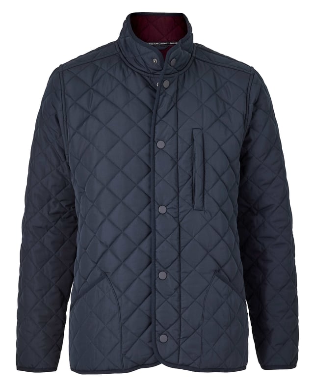 This quilted jacket was the go-to choice for discerning gentlemen last winter - and it's back again to elevate your winter style. Crafted for warmth without restriction, it features refined cotton corduroy trim and multiple pockets to keep your daily essentials at hand. Whether you're navigating city streets or venturing into the countryside, this jacket blends functionality with timeless appeal. Made from 100% polyester quilted outer with a 100% polyester navy lining. Centre back length on size Medium is 72 cm. Edges trimmed in 100% cotton corduroy. Medium weight wadding for extra warmth. Regular fit. Two patch pockets and zipped pocket; back has a poppered flap; matte navy matching studs.
