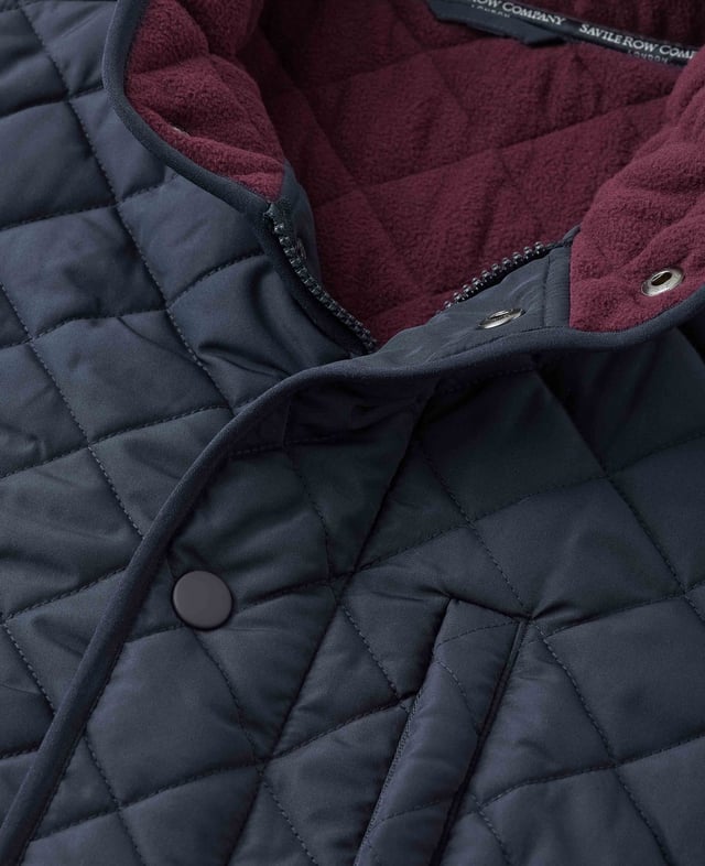 This quilted jacket was the go-to choice for discerning gentlemen last winter - and it's back again to elevate your winter style. Crafted for warmth without restriction, it features refined cotton corduroy trim and multiple pockets to keep your daily essentials at hand. Whether you're navigating city streets or venturing into the countryside, this jacket blends functionality with timeless appeal. Made from 100% polyester quilted outer with a 100% polyester navy lining. Centre back length on size Medium is 72 cm. Edges trimmed in 100% cotton corduroy. Medium weight wadding for extra warmth. Regular fit. Two patch pockets and zipped pocket; back has a poppered flap; matte navy matching studs.