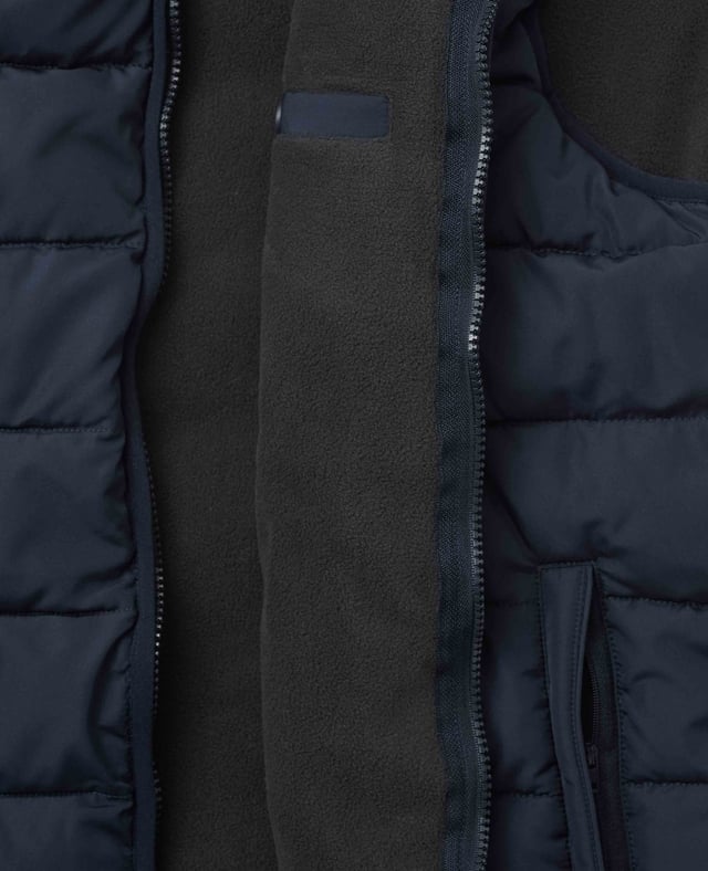 A sustainable choice, this quilted gilet is made using recycled fabrics, including the padding. There's multiple pockets to keep your essentials safe, while the back is cut a little longer than the front to avoid gaping. Tunnel quilted showerproof 100% ocean recycled polyester outer.  Eco friendly down-like 230g wadding for good insulation without the weight.  Lined in 100% grey polyester microfleece.  Outside 2 zipped welt pockets, inside one chest pocket.  Back is a little longer than front.  Funnel neck with front zip.  Centre back length on a size Medium is 72.5cm.  Can be dry cleaned.  Presented in fully recyclable packaging.