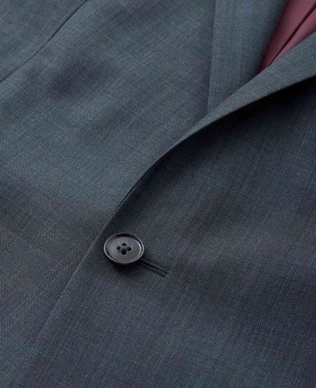 Made from a wool-blend fabric and tailored for a flattering fit, our men's herringbone suit jacket features a two-button fastening and double back vents for ease of movement. Inside you'll find luxury gold lining, while there's multiple pockets to keep your essentials safe. Outer; 44% virgin wool, 53% polyester, 3% elastane 265 grms/m ² lining; 100% polyester. Wool is harvested in a non mulesed manner which is in line with cruelty free policies. Tailored fit. Jacket is single breasted with 2 button front; 2 back vents. Jacket has columbian stitching on inside facing. Gold coloured lining.