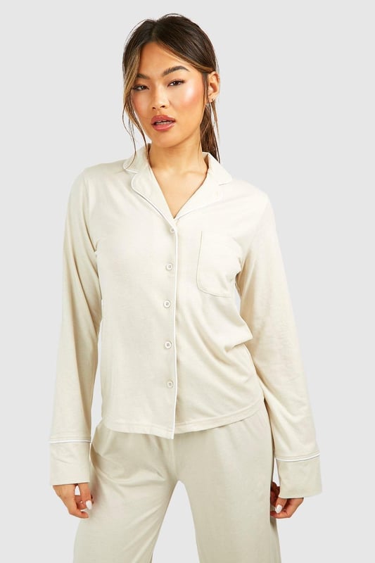 Collared button-front design for a classic look
        Soft jersey fabric for ultimate comfort
        Long sleeves with cuffed details
        Relaxed fit for effortless lounging
        Versatile piece that can be styled for various occasions
    
    Embrace laid-back luxury with this Button Front Lounge Shirt from Boohoo. Perfect for those cosy nights in or lazy weekend mornings, this versatile piece combines style and comfort effortlessly. The classic collared design adds a touch of sophistication to your loungewear collection, while the soft jersey fabric ensures you stay comfortable all day long. Pair it with the matching trousers for a coordinated look, or throw it over your favourite leggings for a more casual vibe. Whether you're binge-watching your latest TV obsession or hosting an intimate brunch with friends, this lounge shirt is your go-to for looking put-together without sacrificing comfort. Its adaptable nature means you can easily dress it up with some statement jewellery for those impromptu video calls or keep it simple for a relaxed day at home. With Boohoo's Button Front Lounge Shirt, you'll redefine your at-home style game.