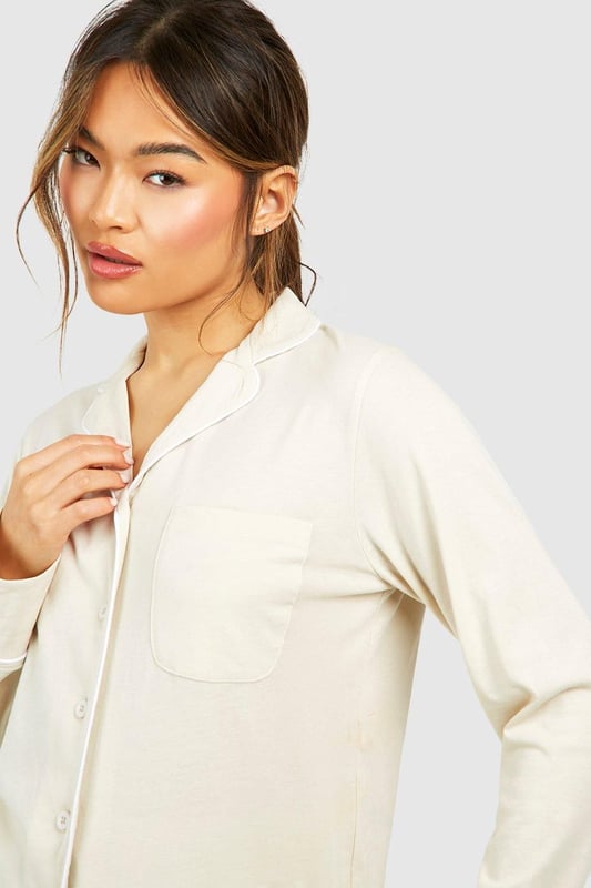 Collared button-front design for a classic look
        Soft jersey fabric for ultimate comfort
        Long sleeves with cuffed details
        Relaxed fit for effortless lounging
        Versatile piece that can be styled for various occasions
    
    Embrace laid-back luxury with this Button Front Lounge Shirt from Boohoo. Perfect for those cosy nights in or lazy weekend mornings, this versatile piece combines style and comfort effortlessly. The classic collared design adds a touch of sophistication to your loungewear collection, while the soft jersey fabric ensures you stay comfortable all day long. Pair it with the matching trousers for a coordinated look, or throw it over your favourite leggings for a more casual vibe. Whether you're binge-watching your latest TV obsession or hosting an intimate brunch with friends, this lounge shirt is your go-to for looking put-together without sacrificing comfort. Its adaptable nature means you can easily dress it up with some statement jewellery for those impromptu video calls or keep it simple for a relaxed day at home. With Boohoo's Button Front Lounge Shirt, you'll redefine your at-home style game.