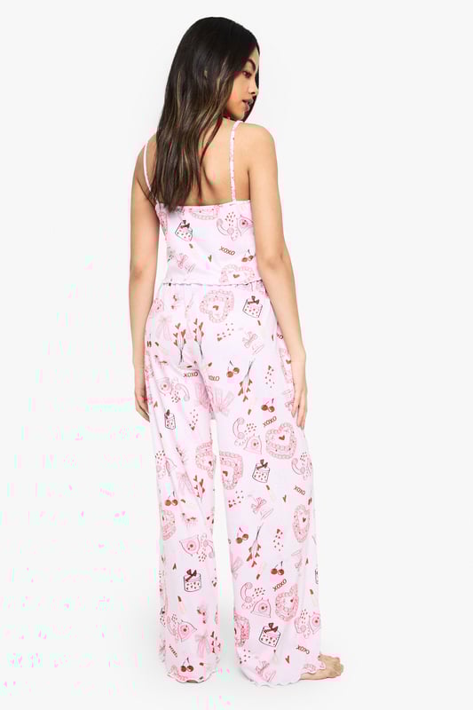 Charming all-over print featuring playful motifs
        Comfortable knitted fabric for a soft feel
        Adjustable spaghetti straps for a customised fit
        Wide-leg trousers for unrestricted movement
        Versatile two-piece set for mix-and-match styling
    
    Drift off to dreamland in style with this delightful nightwear set from Boohoo. The charming all-over print adds a touch of whimsy to your bedtime routine, while the knitted fabric ensures a cosy night's sleep. The adjustable spaghetti straps allow you to find your perfect fit, and the wide-leg trousers offer ample room for movement as you lounge or slumber. This versatile set is perfect for those warm summer nights when you want to feel cool and comfortable. Pair the top with your favourite pyjama bottoms or wear the trousers with a simple vest for a mix-and-match look. Whether you're having a leisurely weekend lie-in or getting ready for a girls' night in, this adorable set will keep you feeling relaxed and looking effortlessly chic.