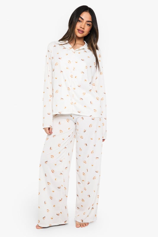 Charming ice cream print pyjama set
        Soft jersey fabric for ultimate comfort
        Long-sleeved button-up top with notched collar
        Matching wide-leg trousers for a relaxed fit
        Versatile two-piece design for mix-and-match options
    
    Indulge in sweet dreams with this delightful ice cream print pyjama set from Boohoo. Perfect for those who crave both style and comfort in their nightwear, this ensemble is crafted from soft jersey fabric to ensure a cosy night's sleep. The long-sleeved top features a classic button-up front and notched collar, adding a touch of sophistication to your bedtime routine. Paired with wide-leg trousers, this set offers unrestricted movement for ultimate relaxation. Whether you're having a lazy Sunday morning or hosting a girls' night in, this pyjama set is versatile enough to suit any casual at-home occasion. Mix and match the pieces with other items in your loungewear collection for endless styling possibilities. Embrace your playful side and make bedtime a little sweeter with this charming pyjama set.