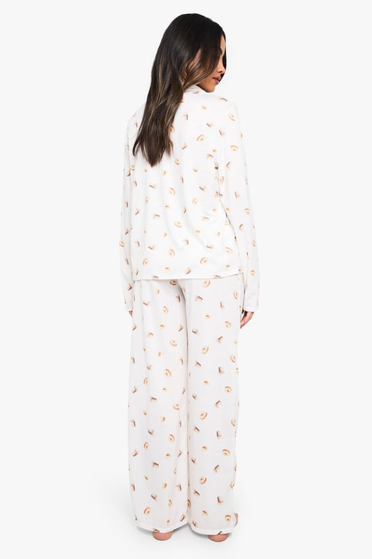 Charming ice cream print pyjama set
        Soft jersey fabric for ultimate comfort
        Long-sleeved button-up top with notched collar
        Matching wide-leg trousers for a relaxed fit
        Versatile two-piece design for mix-and-match options
    
    Indulge in sweet dreams with this delightful ice cream print pyjama set from Boohoo. Perfect for those who crave both style and comfort in their nightwear, this ensemble is crafted from soft jersey fabric to ensure a cosy night's sleep. The long-sleeved top features a classic button-up front and notched collar, adding a touch of sophistication to your bedtime routine. Paired with wide-leg trousers, this set offers unrestricted movement for ultimate relaxation. Whether you're having a lazy Sunday morning or hosting a girls' night in, this pyjama set is versatile enough to suit any casual at-home occasion. Mix and match the pieces with other items in your loungewear collection for endless styling possibilities. Embrace your playful side and make bedtime a little sweeter with this charming pyjama set.