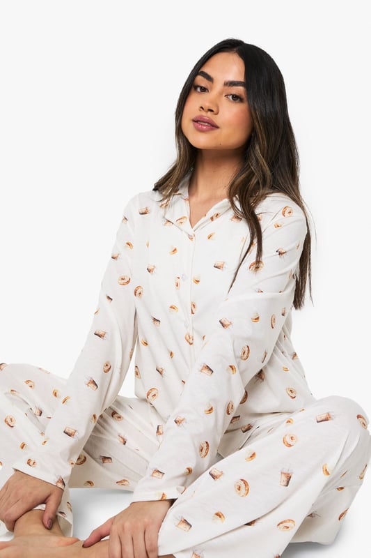 Charming ice cream print pyjama set
        Soft jersey fabric for ultimate comfort
        Long-sleeved button-up top with notched collar
        Matching wide-leg trousers for a relaxed fit
        Versatile two-piece design for mix-and-match options
    
    Indulge in sweet dreams with this delightful ice cream print pyjama set from Boohoo. Perfect for those who crave both style and comfort in their nightwear, this ensemble is crafted from soft jersey fabric to ensure a cosy night's sleep. The long-sleeved top features a classic button-up front and notched collar, adding a touch of sophistication to your bedtime routine. Paired with wide-leg trousers, this set offers unrestricted movement for ultimate relaxation. Whether you're having a lazy Sunday morning or hosting a girls' night in, this pyjama set is versatile enough to suit any casual at-home occasion. Mix and match the pieces with other items in your loungewear collection for endless styling possibilities. Embrace your playful side and make bedtime a little sweeter with this charming pyjama set.