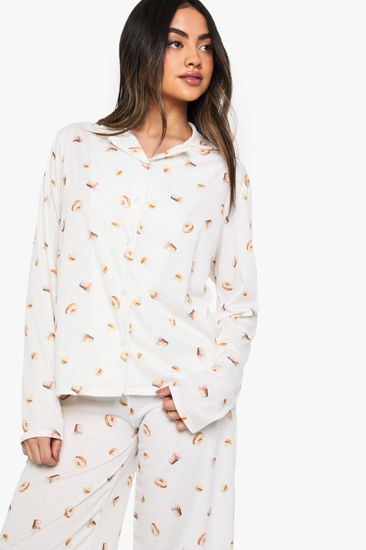 Charming ice cream print pyjama set
        Soft jersey fabric for ultimate comfort
        Long-sleeved button-up top with notched collar
        Matching wide-leg trousers for a relaxed fit
        Versatile two-piece design for mix-and-match options
    
    Indulge in sweet dreams with this delightful ice cream print pyjama set from Boohoo. Perfect for those who crave both style and comfort in their nightwear, this ensemble is crafted from soft jersey fabric to ensure a cosy night's sleep. The long-sleeved top features a classic button-up front and notched collar, adding a touch of sophistication to your bedtime routine. Paired with wide-leg trousers, this set offers unrestricted movement for ultimate relaxation. Whether you're having a lazy Sunday morning or hosting a girls' night in, this pyjama set is versatile enough to suit any casual at-home occasion. Mix and match the pieces with other items in your loungewear collection for endless styling possibilities. Embrace your playful side and make bedtime a little sweeter with this charming pyjama set.