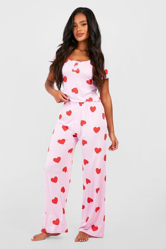 Charming heart print pyjama set
        Button-front top with short sleeves
        Scoop neckline for a feminine touch
        Comfortable wide-leg trousers
        Soft jersey fabric for ultimate comfort
    
    Indulge in sweet dreams with this adorable heart print pyjama set from Boohoo. Perfect for the fashion-forward sleeper, this ensemble combines style and comfort effortlessly. The button-front top features a flattering scoop neckline and short sleeves, ideal for those warm nights. Paired with wide-leg trousers, this set offers unrestricted movement for a restful slumber. The soft jersey fabric ensures a cosy feel against your skin, making it perfect for lounging on lazy weekends or having a girls' night in. Whether you're settling down for a Netflix marathon or enjoying your morning coffee, these pyjamas will keep you feeling chic and comfortable. Embrace your playful side and add a touch of romance to your nightwear collection with this charming set that's sure to become a bedtime favourite.