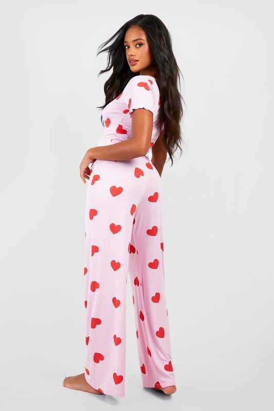 Charming heart print pyjama set
        Button-front top with short sleeves
        Scoop neckline for a feminine touch
        Comfortable wide-leg trousers
        Soft jersey fabric for ultimate comfort
    
    Indulge in sweet dreams with this adorable heart print pyjama set from Boohoo. Perfect for the fashion-forward sleeper, this ensemble combines style and comfort effortlessly. The button-front top features a flattering scoop neckline and short sleeves, ideal for those warm nights. Paired with wide-leg trousers, this set offers unrestricted movement for a restful slumber. The soft jersey fabric ensures a cosy feel against your skin, making it perfect for lounging on lazy weekends or having a girls' night in. Whether you're settling down for a Netflix marathon or enjoying your morning coffee, these pyjamas will keep you feeling chic and comfortable. Embrace your playful side and add a touch of romance to your nightwear collection with this charming set that's sure to become a bedtime favourite.