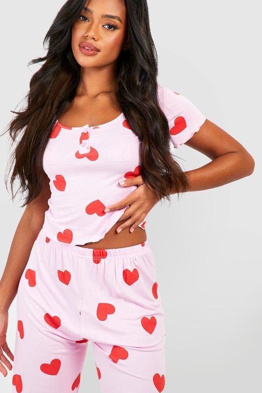 Charming heart print pyjama set
        Button-front top with short sleeves
        Scoop neckline for a feminine touch
        Comfortable wide-leg trousers
        Soft jersey fabric for ultimate comfort
    
    Indulge in sweet dreams with this adorable heart print pyjama set from Boohoo. Perfect for the fashion-forward sleeper, this ensemble combines style and comfort effortlessly. The button-front top features a flattering scoop neckline and short sleeves, ideal for those warm nights. Paired with wide-leg trousers, this set offers unrestricted movement for a restful slumber. The soft jersey fabric ensures a cosy feel against your skin, making it perfect for lounging on lazy weekends or having a girls' night in. Whether you're settling down for a Netflix marathon or enjoying your morning coffee, these pyjamas will keep you feeling chic and comfortable. Embrace your playful side and add a touch of romance to your nightwear collection with this charming set that's sure to become a bedtime favourite.