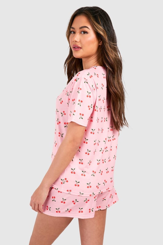 Playful cherry print pyjama set featuring a relaxed t-shirt top and matching shorts
        Soft jersey fabric ensures maximum comfort for lounging and sleeping
        Round neckline and short sleeves offer a classic, fuss-free silhouette
        Loose-fitting shorts with an elasticated waistband for unrestricted movement
        Versatile two-piece design perfect for year-round nightwear
    
    Add a touch of whimsy to your nightwear collection with this charming cherry print pyjama set from Boohoo. The relaxed t-shirt style top pairs perfectly with the comfortable shorts for a coordinated bedtime look that's both cute and practical. The lightweight jersey fabric feels wonderfully soft against the skin, making this set ideal for a restful night's sleep or lazy weekend mornings. Style with fluffy slippers and a cosy dressing gown during cooler months, or wear on its own during warmer weather. This playful set also makes for a delightful gift option or a treat for yourself when your nightwear drawer needs a refresh. The timeless silhouette and fun print reflect Boohoo's commitment to creating fashion that's both accessible and on-trend, ensuring you look stylish even when you're winding down.
