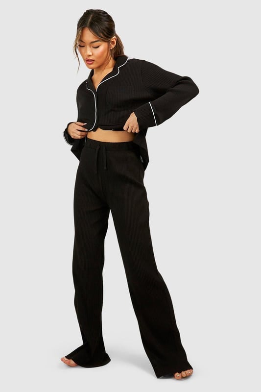 Ribbed jersey fabric for comfort and texture
        Tie waist detail for adjustable fit
        Wide-leg design for relaxed silhouette
        Matching cropped jacket with contrasting piping
        Versatile two-piece set for effortless lounging
    
    Embrace laid-back luxury with this rib tie waist lounge trouser set from Boohoo. Perfect for those cosy nights in or lazy weekend mornings, this ensemble offers both style and comfort. The wide-leg trousers feature a flattering high waist with an adjustable tie, allowing you to customise your fit. Pair with the matching cropped jacket, adorned with chic contrasting piping, for a coordinated look that's anything but ordinary. Whether you're binge-watching your favourite series or hosting an intimate brunch at home, this set will keep you feeling fabulous and relaxed. Style with soft slippers and your favourite oversized cardigan for ultimate comfort, or dress it up with statement earrings and a messy bun for those impromptu video calls. This Boohoo loungewear set is the epitome of effortless chic, ensuring you look put-together even on your most casual days.