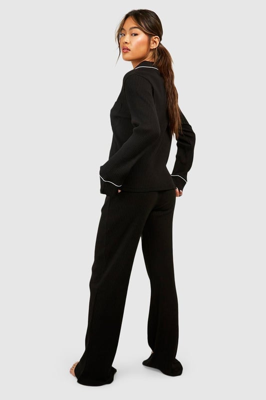 Ribbed jersey fabric for comfort and texture
        Tie waist detail for adjustable fit
        Wide-leg design for relaxed silhouette
        Matching cropped jacket with contrasting piping
        Versatile two-piece set for effortless lounging
    
    Embrace laid-back luxury with this rib tie waist lounge trouser set from Boohoo. Perfect for those cosy nights in or lazy weekend mornings, this ensemble offers both style and comfort. The wide-leg trousers feature a flattering high waist with an adjustable tie, allowing you to customise your fit. Pair with the matching cropped jacket, adorned with chic contrasting piping, for a coordinated look that's anything but ordinary. Whether you're binge-watching your favourite series or hosting an intimate brunch at home, this set will keep you feeling fabulous and relaxed. Style with soft slippers and your favourite oversized cardigan for ultimate comfort, or dress it up with statement earrings and a messy bun for those impromptu video calls. This Boohoo loungewear set is the epitome of effortless chic, ensuring you look put-together even on your most casual days.