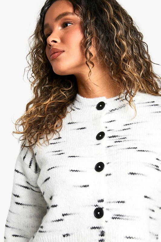 Textured knit design with unique dash pattern
        Cropped length for a modern silhouette
        Button-front closure for versatile styling
        Ribbed cuffs and hem for a snug fit
        Relaxed shoulder line for comfortable wear
    
    The Kastiger Strick-Cardigan from Boohoo is a versatile piece that effortlessly blends comfort with style. This eye-catching cardigan features a distinctive dash pattern that adds visual interest to any ensemble. The cropped length is perfect for pairing with high-waisted trousers or skirts, creating a balanced and trendy silhouette. For a casual day out, style it with wide-leg jeans and trainers, as seen on the model. The button-front closure allows for multiple styling options - wear it fully buttoned as a standalone top or open over a simple tee for a layered look. The ribbed cuffs and hem ensure a snug fit, while the relaxed shoulder line offers ease of movement. This cardigan is ideal for various casual occasions, from coffee dates to family gatherings. Its adaptable nature makes it a wardrobe staple that can be dressed up or down to suit your mood and the event.