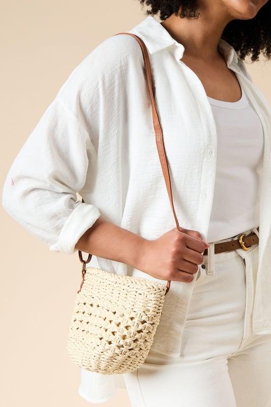 Intricately woven rattan bucket bag with distinctive open-weave pattern
        Contrasting leather shoulder strap for comfortable cross-body wear
        Spacious interior with synthetic lining for practicality
        Compact yet roomy design perfect for everyday essentials
        Authentic natural texture that adds artisanal charm to any outfit
    
    The Sara Rattan Detail Bucket Bag from Oasis combines natural texture with feminine charm. The beautifully crafted woven exterior showcases intricate detailing, whilst the leather strap adds a touch of sophistication and durability. Style this versatile piece with a crisp white broderie anglaise dress for garden parties, or pair with relaxed linen trousers and a simple tee for weekend brunches. The bucket silhouette offers ample space for your mobile, wallet and beauty essentials without overwhelming your look. This bag transitions effortlessly from daytime shopping trips to casual evening meals, making it a wardrobe staple for the warmer months. The neutral tones complement virtually any ensemble, allowing this charming accessory to become your go-to companion for family gatherings and casual outings alike.