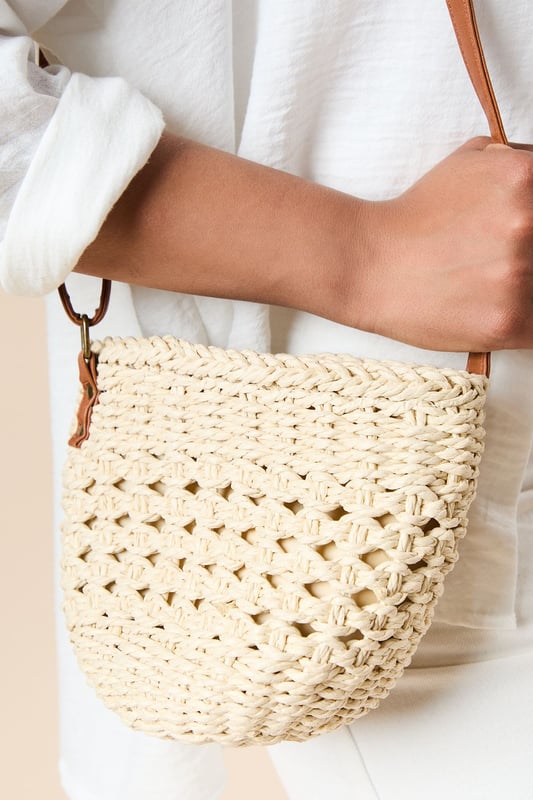 Intricately woven rattan bucket bag with distinctive open-weave pattern
        Contrasting leather shoulder strap for comfortable cross-body wear
        Spacious interior with synthetic lining for practicality
        Compact yet roomy design perfect for everyday essentials
        Authentic natural texture that adds artisanal charm to any outfit
    
    The Sara Rattan Detail Bucket Bag from Oasis combines natural texture with feminine charm. The beautifully crafted woven exterior showcases intricate detailing, whilst the leather strap adds a touch of sophistication and durability. Style this versatile piece with a crisp white broderie anglaise dress for garden parties, or pair with relaxed linen trousers and a simple tee for weekend brunches. The bucket silhouette offers ample space for your mobile, wallet and beauty essentials without overwhelming your look. This bag transitions effortlessly from daytime shopping trips to casual evening meals, making it a wardrobe staple for the warmer months. The neutral tones complement virtually any ensemble, allowing this charming accessory to become your go-to companion for family gatherings and casual outings alike.