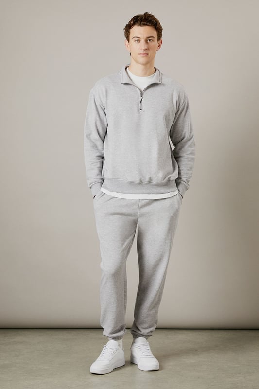 Soft jersey fabric for all-day comfort and ease of movement
        Relaxed fit through the leg with tapered ankle cuffs
        Adjustable drawstring waist for a customised fit
        Side pockets for practicality and casual styling
        Versatile design that pairs effortlessly with both casual and athleisure wear
    
    These classic jersey joggers deliver the perfect balance of comfort and style for the modern man. The relaxed silhouette offers unrestricted movement while the tapered ankle creates a more refined finish than traditional tracksuit bottoms. As demonstrated by our model, they pair brilliantly with a matching quarter-zip sweatshirt and crisp white trainers for a coordinated look that works for weekend errands or meeting mates at the local. The soft jersey fabric makes these joggers ideal for lounging at home, but they're equally suited to casual outings or sports activities. Their understated design means they'll integrate seamlessly into your existing wardrobe, working well with everything from simple t-shirts to lightweight jackets when the weather turns. A true wardrobe essential that combines practicality with laid-back style.