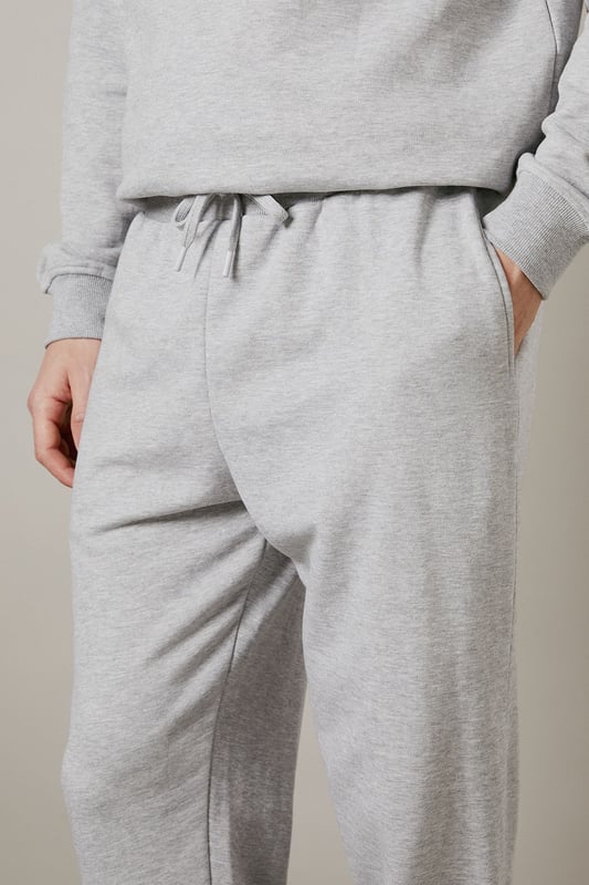 Soft jersey fabric for all-day comfort and ease of movement
        Relaxed fit through the leg with tapered ankle cuffs
        Adjustable drawstring waist for a customised fit
        Side pockets for practicality and casual styling
        Versatile design that pairs effortlessly with both casual and athleisure wear
    
    These classic jersey joggers deliver the perfect balance of comfort and style for the modern man. The relaxed silhouette offers unrestricted movement while the tapered ankle creates a more refined finish than traditional tracksuit bottoms. As demonstrated by our model, they pair brilliantly with a matching quarter-zip sweatshirt and crisp white trainers for a coordinated look that works for weekend errands or meeting mates at the local. The soft jersey fabric makes these joggers ideal for lounging at home, but they're equally suited to casual outings or sports activities. Their understated design means they'll integrate seamlessly into your existing wardrobe, working well with everything from simple t-shirts to lightweight jackets when the weather turns. A true wardrobe essential that combines practicality with laid-back style.
