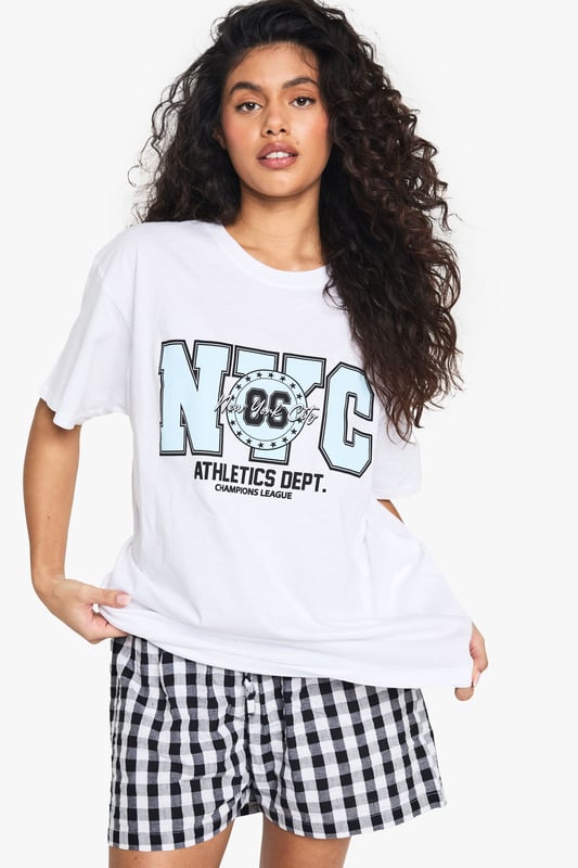 Oversized fit for ultimate comfort and laid-back style
        Bold NYC Athletics Dept graphic print for a sporty urban vibe
        Versatile cotton fabric suitable for all-day wear
        Short sleeves and crew neckline for a classic T-shirt silhouette
        Relaxed dropped shoulders enhancing the casual look
    
    Embrace the urban-chic aesthetic with this oversized T-shirt featuring a striking NYC Athletics Dept print. Perfect for those seeking a blend of comfort and style, this versatile piece is ideal for casual outings or relaxed weekends. Pair it with gingham shorts as shown for a playful contrast, or style it with your favourite denim for an effortless everyday look. The roomy fit allows for easy layering - throw on a denim jacket for cooler evenings or wear it over a long-sleeved top when the temperature drops. Dress it up with a leather skirt and trainers for a trendy night out, or keep it casual with joggers for a quick coffee run. This T-shirt is a must-have for the fashion-forward individual who values both comfort and street-style credibility.
