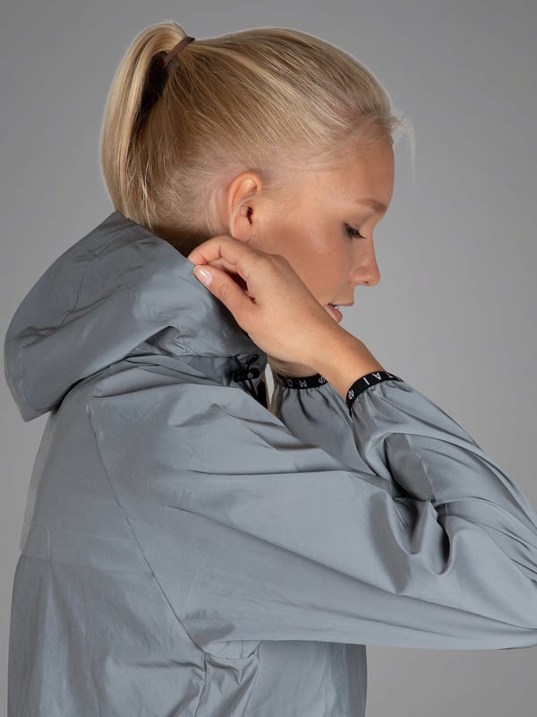 Este cortavientos combina material reflectante con un diseño deportivo para ofrecer la máxima seguridad en la oscuridad.
Las aberturas de ventilación en la espalda y el forro de malla transpirable garantizan una agradable sensación de sequedad.
El material exterior repelente al agua protege contra el viento y la lluvia, perfecto para condiciones cambiantes.
La capucha ajustable, los puños elásticos y el logotipo bordado completan su aspecto funcional.
Una compañera elegante para tus entrenamientos al aire libre: ligera, segura y con estilo.