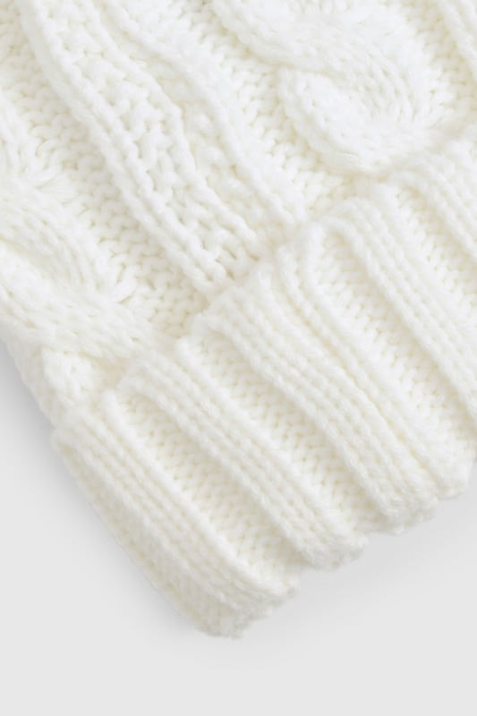 Chunky cable knit design for a classic winter look
        Soft acrylic fabric for comfort and warmth
        Oversized faux fur pom-pom for a playful touch
        Ribbed cuff for a snug fit
        Versatile one-size-fits-all styling
    
    Embrace the chilly weather with this charming Cable Knit Faux Pom Beanie from Boohoo. The chunky cable knit pattern adds a timeless appeal, while the oversized faux fur pom-pom injects a dash of fun to your winter ensemble. Perfect for casual outings or family gatherings, this beanie pairs effortlessly with your favourite jumper and jeans combo. For a trendy look, team it with a longline puffer coat, thermal leggings, and chunky trainers. The versatile design makes it an ideal accessory for various cold-weather activities, from ice skating with friends to cosy walks in the park. With its soft acrylic fabric and snug fit, this beanie ensures you stay warm and stylish throughout the season.