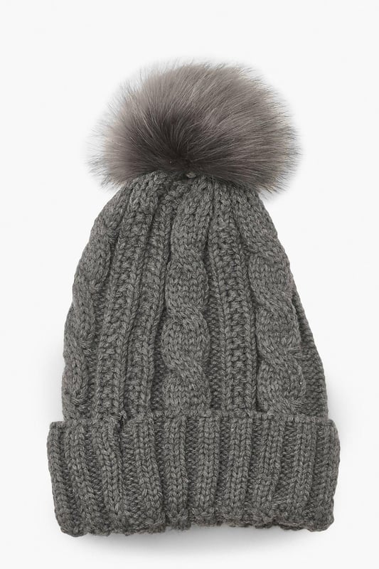 Chunky cable knit design for a classic winter look
        Soft acrylic fabric for comfort and warmth
        Oversized faux fur pom-pom for a playful touch
        Ribbed cuff for a snug fit
        Versatile one-size-fits-all styling
    
    Embrace the chilly weather with this charming Cable Knit Faux Pom Beanie from Boohoo. The chunky cable knit pattern adds a timeless appeal, while the oversized faux fur pom-pom injects a dash of fun to your winter ensemble. Perfect for casual outings or family gatherings, this beanie pairs effortlessly with your favourite jumper and jeans combo. For a trendy look, team it with a longline puffer coat, thermal leggings, and chunky trainers. The versatile design makes it an ideal accessory for various cold-weather activities, from ice skating with friends to cosy walks in the park. With its soft acrylic fabric and snug fit, this beanie ensures you stay warm and stylish throughout the season.