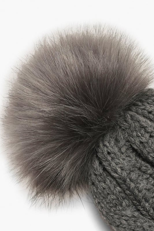 Chunky cable knit design for a classic winter look
        Soft acrylic fabric for comfort and warmth
        Oversized faux fur pom-pom for a playful touch
        Ribbed cuff for a snug fit
        Versatile one-size-fits-all styling
    
    Embrace the chilly weather with this charming Cable Knit Faux Pom Beanie from Boohoo. The chunky cable knit pattern adds a timeless appeal, while the oversized faux fur pom-pom injects a dash of fun to your winter ensemble. Perfect for casual outings or family gatherings, this beanie pairs effortlessly with your favourite jumper and jeans combo. For a trendy look, team it with a longline puffer coat, thermal leggings, and chunky trainers. The versatile design makes it an ideal accessory for various cold-weather activities, from ice skating with friends to cosy walks in the park. With its soft acrylic fabric and snug fit, this beanie ensures you stay warm and stylish throughout the season.