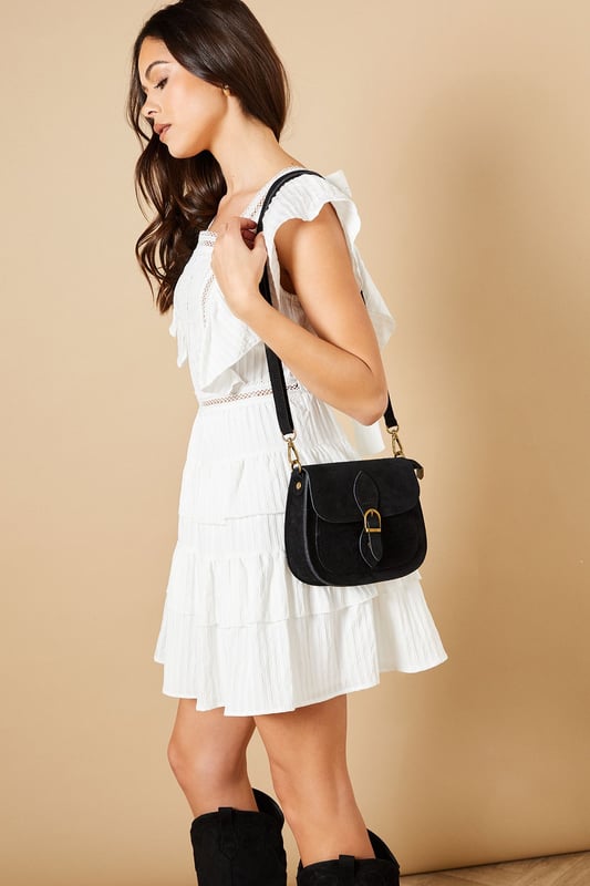 Classic saddle bag silhouette with elegant curved design
        Soft suede-look finish for a tactile, luxurious feel
        Adjustable cross body strap for versatile wearing options
        Secure front flap with decorative buckle closure
        Practical interior compartment with ample space for essentials
    
    The Polarisia Suede Cross Body Saddle Bag combines timeless style with everyday practicality. The distinctive curved saddle shape creates a feminine silhouette that complements both casual and smart-casual outfits. Style with a floaty summer dress and western boots for a bohemian daytime look, or pair with straight-leg jeans and a crisp white shirt for weekend brunches. The adjustable strap allows for comfortable wear across the body, keeping your hands free while shopping or at informal gatherings. This versatile bag transitions effortlessly from day to evening, making it perfect for family gatherings or casual meet-ups with friends. The suede-look finish adds texture and interest to simple outfits, while the practical size ensures you can carry all your daily necessities without bulk.
