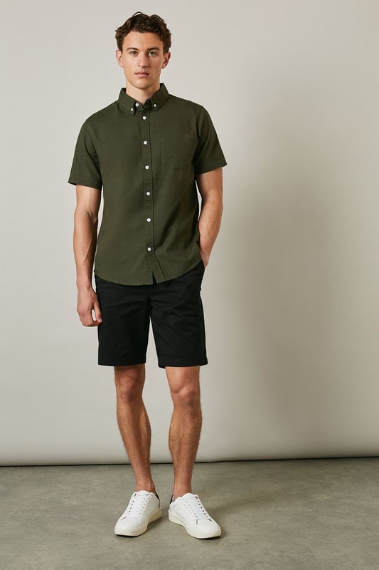 Textured woven cotton fabric with subtle surface detail for added visual interest
        Classic button-down collar with short sleeves for warm-weather comfort
        Clean-cut design featuring a single back pleat for improved movement
        Traditional front button fastening with contrasting white buttons
        Versatile regular fit that suits a variety of body types
    
    This Maine textured short sleeve shirt combines timeless style with everyday practicality. The breathable cotton construction ensures all-day comfort whilst the subtle texture adds character to this wardrobe essential. Perfect for casual weekend outings, pair it with dark shorts and white trainers as shown for an effortlessly cool summer look. The versatile design also works brilliantly with chinos or jeans for family gatherings or informal social events. Layer under a lightweight jacket when the temperature drops or wear it unbuttoned over a plain t-shirt for a more relaxed approach. The button-down collar maintains a smart appearance even without a tie, making this shirt an ideal choice for those occasions that sit between casual and smart-casual. Machine washable at 30 degrees, it's designed to maintain its shape and appearance with proper care.