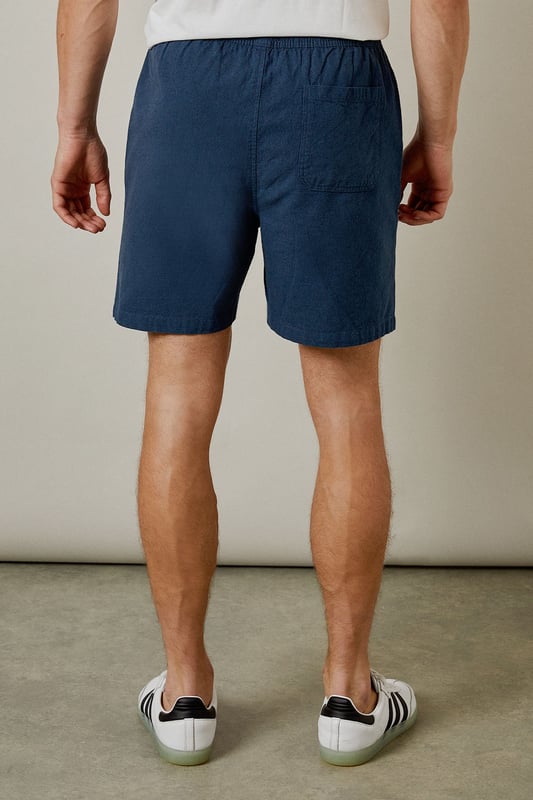 Textured woven fabric with distinctive marl finish for added visual interest
        Comfortable elasticated waistband for an easy, relaxed fit
        Practical back pocket for essential items
        Mid-thigh length offering the perfect balance between comfort and style
        Versatile navy hue that pairs effortlessly with your existing wardrobe
    
    These Burton textured casual shorts deliver the perfect combination of comfort and laid-back style for the modern man. The cotton fabric provides breathability for those warmer days, whether you're heading to a weekend BBQ or watching the match at your local. Style them as shown with a crisp white t-shirt and trainers for an effortless daytime look, or pair with a short-sleeved shirt for casual gatherings with friends and family. The relaxed fit ensures all-day comfort without compromising on style, making these shorts a versatile addition to your summer rotation. They're ideal for sporting events, pub garden sessions, or simply lounging at home. Machine washable at 30 degrees, these shorts offer practicality alongside their casual charm - a true wardrobe essential for the British summer.