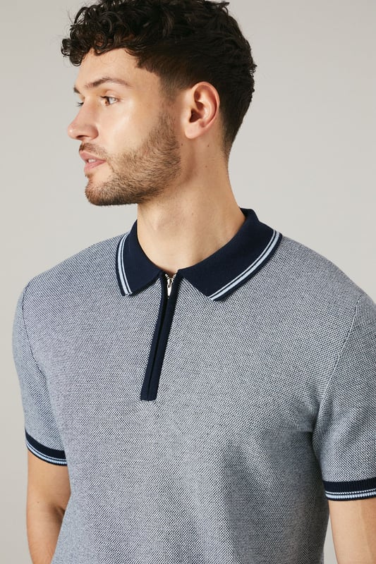 Birdseye knitted texture for a sophisticated look
        Contrasting collar and cuffs for a smart finish
        Quarter-zip neckline for adjustable comfort
        Short sleeves ideal for warmer weather
        Versatile design suitable for various casual occasions
    
    This Maine birdseye knitted polo shirt combines comfort with style, making it a versatile addition to your wardrobe. The textured knit adds depth and interest to the garment, while the contrasting collar and cuffs create a refined edge. Perfect for casual outings, this polo can be effortlessly styled for a range of events. Pair it with dark trousers and white trainers for a smart-casual look ideal for family gatherings or weekend brunches. The quarter-zip neckline allows for customisable comfort, adapting to your preference and the weather. Made from 100% cotton, this polo ensures breathability and ease of care, making it a practical choice for the modern man who values both style and functionality. Whether you're heading to a casual meet-up with friends or a relaxed day out, this Maine polo will keep you looking polished without compromising on comfort.