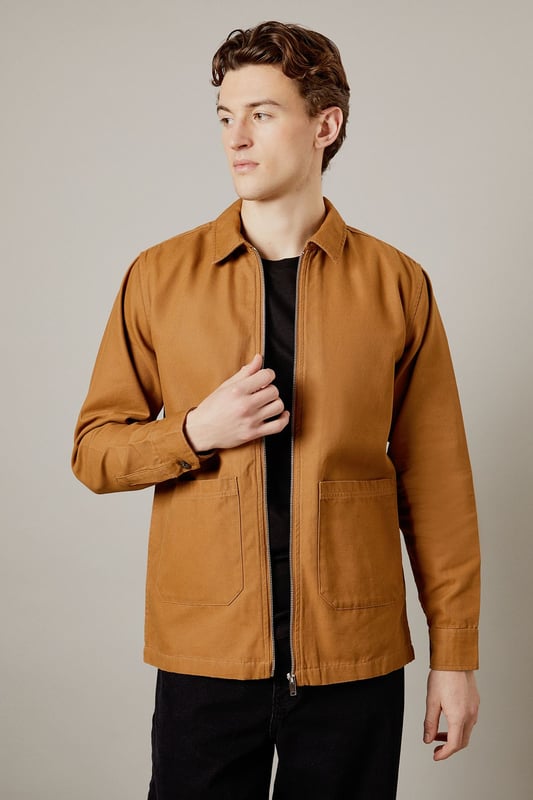 Tan Logan Canvas Jacket Versatile canvas jacket with a classic collar design
Full-length zip closure for easy wear
Spacious patch pockets for practicality
Clean-cut silhouette with a straight hem
Durable woven fabric ideal for everyday wear
The Logan Canvas Jacket from Burton is a quintessential piece for the modern British gent who values both style and functionality. This jacket strikes the perfect balance between casual cool and practical design, making it an ideal choice for various occasions. Pair it with dark trousers and trainers for a laid-back pub outing with mates, or throw it over a crisp shirt for family gatherings. The versatile nature of this jacket allows for effortless styling, whether you're heading to a weekend football match or enjoying a casual day out. Its durable fabric ensures it can withstand the unpredictable British weather, while its timeless design means it'll remain a wardrobe staple for seasons to come. For a smart-casual look, layer it over a plain t-shirt and pair with chinos - perfect for those impromptu after-work drinks or a relaxed date night at your local.