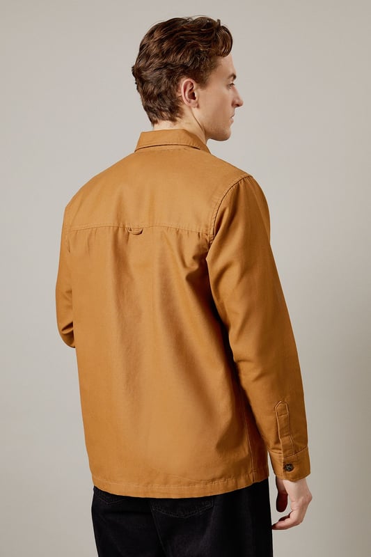 Tan Logan Canvas Jacket Versatile canvas jacket with a classic collar design
Full-length zip closure for easy wear
Spacious patch pockets for practicality
Clean-cut silhouette with a straight hem
Durable woven fabric ideal for everyday wear
The Logan Canvas Jacket from Burton is a quintessential piece for the modern British gent who values both style and functionality. This jacket strikes the perfect balance between casual cool and practical design, making it an ideal choice for various occasions. Pair it with dark trousers and trainers for a laid-back pub outing with mates, or throw it over a crisp shirt for family gatherings. The versatile nature of this jacket allows for effortless styling, whether you're heading to a weekend football match or enjoying a casual day out. Its durable fabric ensures it can withstand the unpredictable British weather, while its timeless design means it'll remain a wardrobe staple for seasons to come. For a smart-casual look, layer it over a plain t-shirt and pair with chinos - perfect for those impromptu after-work drinks or a relaxed date night at your local.
