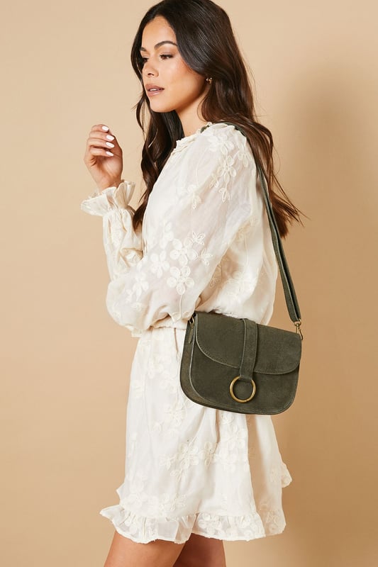 Structured saddle bag silhouette with distinctive curved edges
        Statement gold-tone ring detail on the front flap closure
        Adjustable cross body strap for versatile wearing options
        Suede finish for a tactile, luxurious feel
        Compact yet practical interior with enough space for daily essentials
    
    The Thessina Saddle Bag from Oasis combines timeless design with contemporary detailing. The structured silhouette maintains its shape throughout the day, whilst the distinctive gold-tone ring hardware adds a touch of sophistication. Perfect for daytime outings, this versatile bag complements casual ensembles beautifully. Style with a floaty white dress and ankle boots for weekend brunches, or pair with jeans and a crisp blouse for shopping trips with friends. The adjustable strap allows for comfortable wear across the body, keeping your hands free for browsing or holding a coffee. This bag strikes the ideal balance between fashion and function - small enough to remain unobtrusive yet roomy enough to hold your phone, wallet, keys and favourite lipstick for quick touch-ups throughout the day.