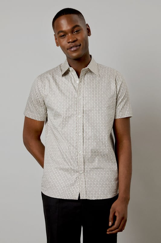 Distinctive all-over print design
        Classic short sleeve silhouette
        Comfortable woven cotton fabric
        Versatile button-up style
        Tailored fit for a smart-casual look
    
    This Burton short sleeve shirt is the perfect addition to your casual wardrobe. The distinctive all-over print adds character to this classic piece, making it ideal for various occasions. Whether you're heading to the pub with mates or attending a family gathering, this shirt has you covered. Style it with dark trousers and trainers for a laid-back yet put-together look, as shown in the images. For a more relaxed vibe, leave it unbuttoned over a plain t-shirt. The woven cotton fabric ensures comfort throughout the day, while the tailored fit creates a smart silhouette without compromising on ease of movement. This versatile shirt is a must-have for the modern British gent who appreciates timeless style with a contemporary twist.