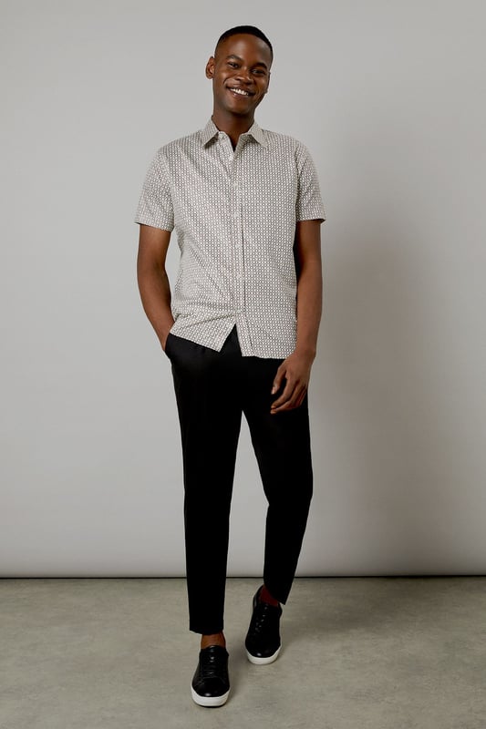 Distinctive all-over print design
        Classic short sleeve silhouette
        Comfortable woven cotton fabric
        Versatile button-up style
        Tailored fit for a smart-casual look
    
    This Burton short sleeve shirt is the perfect addition to your casual wardrobe. The distinctive all-over print adds character to this classic piece, making it ideal for various occasions. Whether you're heading to the pub with mates or attending a family gathering, this shirt has you covered. Style it with dark trousers and trainers for a laid-back yet put-together look, as shown in the images. For a more relaxed vibe, leave it unbuttoned over a plain t-shirt. The woven cotton fabric ensures comfort throughout the day, while the tailored fit creates a smart silhouette without compromising on ease of movement. This versatile shirt is a must-have for the modern British gent who appreciates timeless style with a contemporary twist.