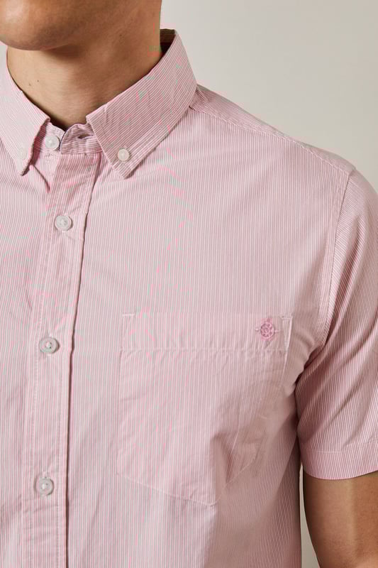 Fine stripe pattern adds subtle visual interest to this classic short sleeve shirt
        Button-down collar provides a neat, structured finish
        Convenient chest pocket detail for added functionality
        Crafted from pure cotton for breathable comfort in warmer weather
        Regular fit design offers ease of movement for everyday wear
    
    This Maine short sleeve shirt combines timeless style with warm-weather practicality. The fine stripe pattern creates a refined yet relaxed aesthetic that transitions effortlessly from day to evening occasions. Style it as seen with neutral chino shorts and white trainers for a polished casual look perfect for weekend brunches or garden gatherings. For smarter occasions, pair with tailored trousers and loafers. The pure cotton fabric ensures all-day comfort even during the warmest days, while the versatile design makes it an essential addition to your summer wardrobe. The button-down collar maintains a neat appearance throughout wear, making this shirt equally suitable for casual office environments or laid-back social events. A true wardrobe staple that offers endless styling possibilities throughout the season.