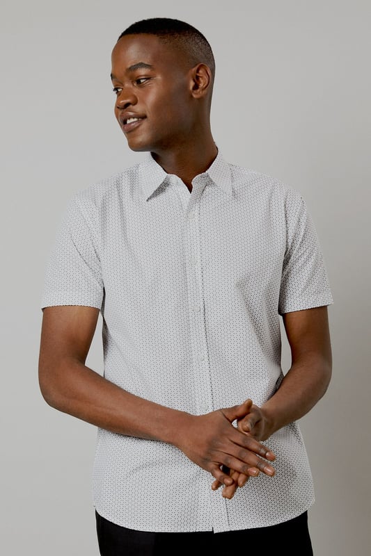 Crafted from pure cotton for exceptional comfort and breathability
        Subtle geo print pattern adds contemporary visual interest
        Classic collar and button-through front for a timeless silhouette
        Short sleeves designed for warm-weather versatility
        Regular fit provides ease of movement for all-day wear
    
    This Burton geo print shirt combines classic styling with modern detailing, perfect for the man who appreciates understated sophistication. The lightweight cotton construction makes it ideal for casual summer occasions, whilst the versatile design allows for effortless styling. Pair with dark trousers as shown for an evening at the pub with mates, or team with chino shorts for family barbecues and weekend outings. The clean lines and subtle pattern work equally well for casual Fridays at the office - simply add a lightweight blazer to sharpen the look. Easy to care for and comfortable to wear, this shirt represents the perfect balance of practicality and style that Burton is known for. A wardrobe essential that will serve you well throughout the warmer months.