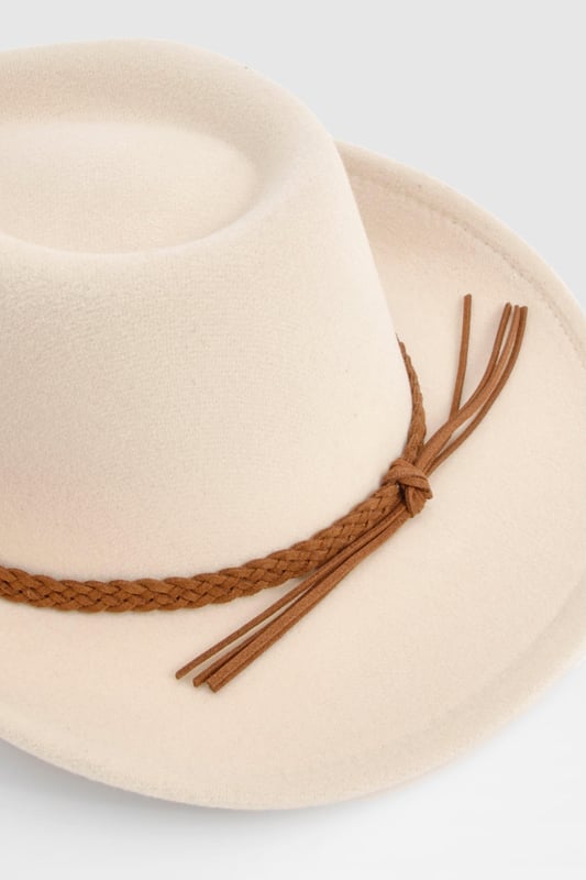 Classic cowboy hat silhouette with a wide brim
        Distinctive braided detail around the crown
        Decorative tassel accent for added flair
        Structured design maintains shape
        Versatile accessory for various casual outfits
    
    Channel your inner cowgirl with this eye-catching Western-inspired hat. The braided detail and playful tassel add a touch of bohemian charm to the classic cowboy silhouette. Perfect for festivals, outdoor events, or simply adding a dash of Wild West flair to your everyday look. Style it with a denim waistcoat and distressed shorts for a carefree summer ensemble, or pair it with a flowing maxi dress for a more romantic take on festival fashion. This hat is not just an accessory; it's a statement piece that will transform your casual outfits into head-turning looks. Whether you're heading to a family barbecue or a day out with friends, this versatile hat will keep you stylish and shaded in equal measure.