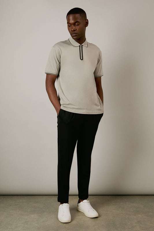 From Burton's exclusive 1904 Collection, featuring mercerised cotton for enhanced lustre and durability
        Quarter-zip neck design with contrast tipping detail along the collar and sleeves
        Classic polo silhouette with short sleeves for comfortable everyday wear
        Soft cotton fabric with a smooth, refined finish that maintains shape throughout the day
        Versatile design that transitions effortlessly from casual daywear to relaxed evening settings
    
    This 1904 Mercerised Zip Neck Polo represents Burton's commitment to timeless menswear with contemporary touches. The quarter-zip detail adds a distinctive element to the classic polo silhouette, whilst the mercerised finish gives the cotton a subtle sheen that distinguishes it from ordinary polos. Style with dark trousers and white trainers as shown for a smart-casual look perfect for weekend pub gatherings or family barbecues. For a more relaxed approach, pair with your favourite denim and canvas trainers. The clean lines and understated design make this polo an excellent choice for casual office environments or sporting events where you want to look put-together without appearing overdressed. A versatile wardrobe staple that works across seasons - layer under a lightweight jacket during cooler months or wear alone when temperatures rise.