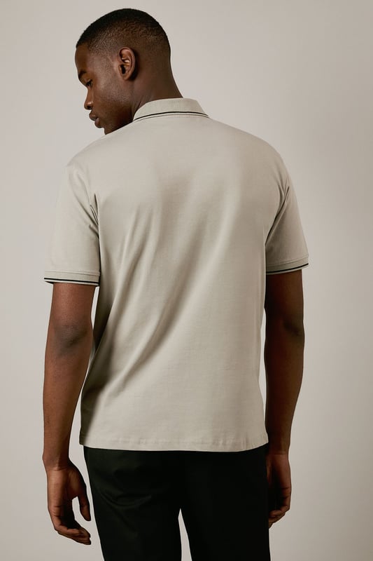 From Burton's exclusive 1904 Collection, featuring mercerised cotton for enhanced lustre and durability
        Quarter-zip neck design with contrast tipping detail along the collar and sleeves
        Classic polo silhouette with short sleeves for comfortable everyday wear
        Soft cotton fabric with a smooth, refined finish that maintains shape throughout the day
        Versatile design that transitions effortlessly from casual daywear to relaxed evening settings
    
    This 1904 Mercerised Zip Neck Polo represents Burton's commitment to timeless menswear with contemporary touches. The quarter-zip detail adds a distinctive element to the classic polo silhouette, whilst the mercerised finish gives the cotton a subtle sheen that distinguishes it from ordinary polos. Style with dark trousers and white trainers as shown for a smart-casual look perfect for weekend pub gatherings or family barbecues. For a more relaxed approach, pair with your favourite denim and canvas trainers. The clean lines and understated design make this polo an excellent choice for casual office environments or sporting events where you want to look put-together without appearing overdressed. A versatile wardrobe staple that works across seasons - layer under a lightweight jacket during cooler months or wear alone when temperatures rise.