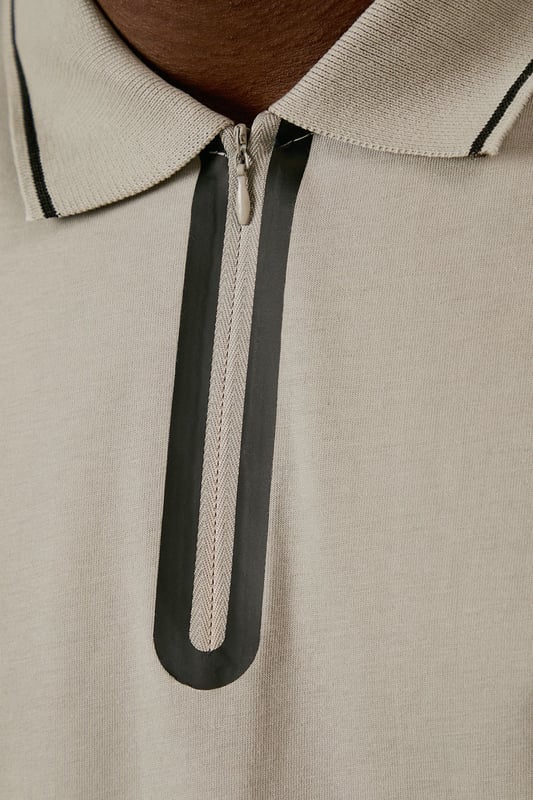 From Burton's exclusive 1904 Collection, featuring mercerised cotton for enhanced lustre and durability
        Quarter-zip neck design with contrast tipping detail along the collar and sleeves
        Classic polo silhouette with short sleeves for comfortable everyday wear
        Soft cotton fabric with a smooth, refined finish that maintains shape throughout the day
        Versatile design that transitions effortlessly from casual daywear to relaxed evening settings
    
    This 1904 Mercerised Zip Neck Polo represents Burton's commitment to timeless menswear with contemporary touches. The quarter-zip detail adds a distinctive element to the classic polo silhouette, whilst the mercerised finish gives the cotton a subtle sheen that distinguishes it from ordinary polos. Style with dark trousers and white trainers as shown for a smart-casual look perfect for weekend pub gatherings or family barbecues. For a more relaxed approach, pair with your favourite denim and canvas trainers. The clean lines and understated design make this polo an excellent choice for casual office environments or sporting events where you want to look put-together without appearing overdressed. A versatile wardrobe staple that works across seasons - layer under a lightweight jacket during cooler months or wear alone when temperatures rise.