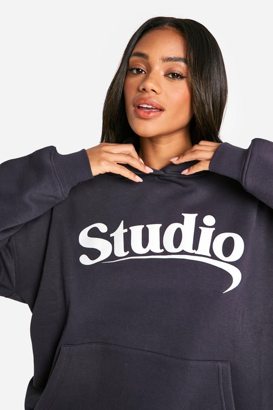 Oversized fit for ultimate comfort and style
        Bold 'Studio' slogan print across the chest
        Spacious hood for added warmth and casual flair
        Convenient front pocket for essentials
        Ribbed cuffs and hem for a snug fit
    
    Make a statement in this trendy oversized hoodie, perfect for those who love to combine comfort with street-style edge. The bold 'Studio' slogan across the chest adds a touch of urban cool to your casual wardrobe. Pair it with wide-leg trousers and trainers for a relaxed weekend look, or throw it over cycling shorts and chunky boots for an edgy athleisure vibe. Ideal for lazy Sundays, coffee runs, or casual meet-ups with friends, this hoodie is versatile enough to take you from daytime errands to evening chill-outs. Layer it over a long-sleeved tee for extra warmth during cooler months, or wear it solo as a comfy throw-on piece. The oversized fit allows for easy movement, making it a go-to choice for your active lifestyle. Whether you're heading to the gym, running errands, or simply lounging at home, this hoodie promises to keep you stylish and cosy all day long.